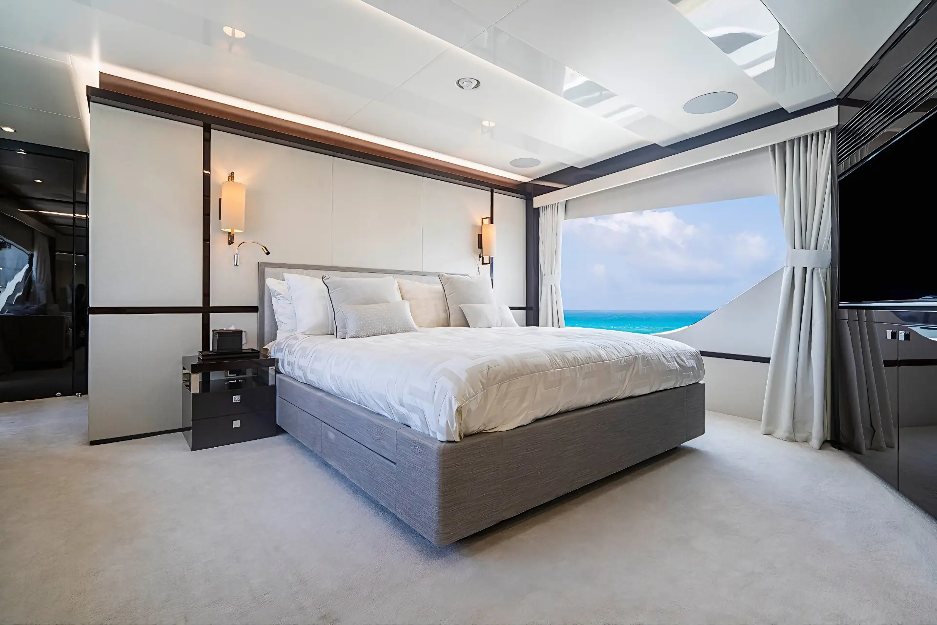 Master bedroom with large bed and windows on Sunseeker 95 Quantum.