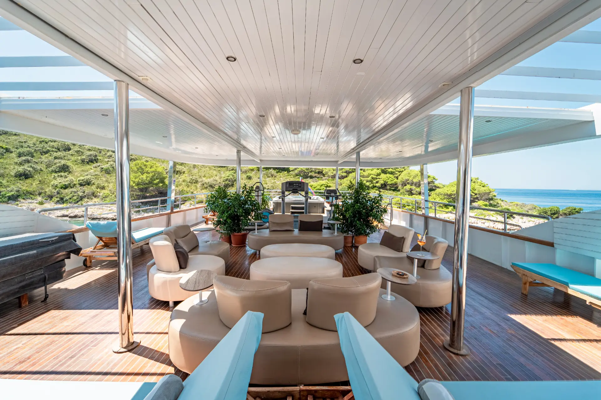 Close aerial view of Mini Cruiser Riva’s sundeck showcasing a stylish lounge area with elegant coffee tables and comfortable seating.