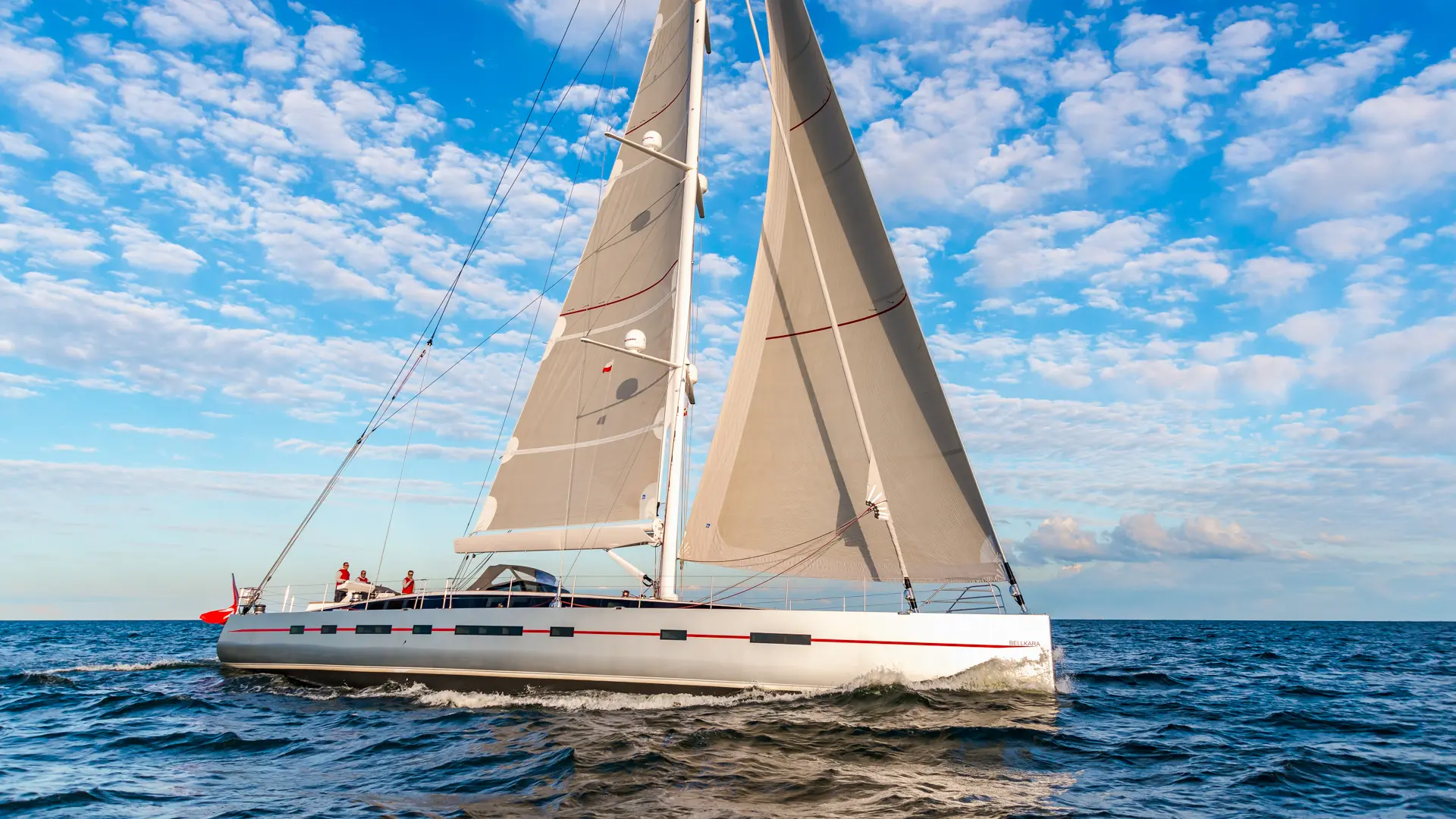 Luxury sailing yacht Bellkara - full sails up, side view showcasing modern design and powerful sail performance.