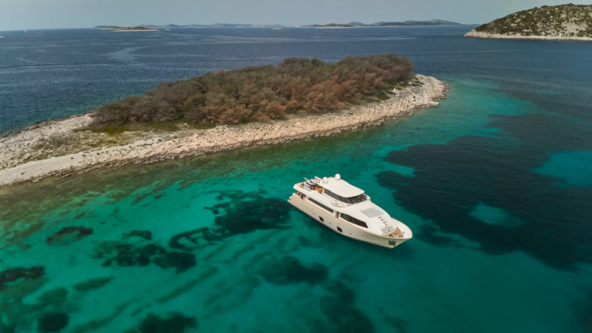 Luxury motor yacht Navetta 26 – aerial view, anchored in turquoise bay near Croatian coastline, perfect for charter escapes.