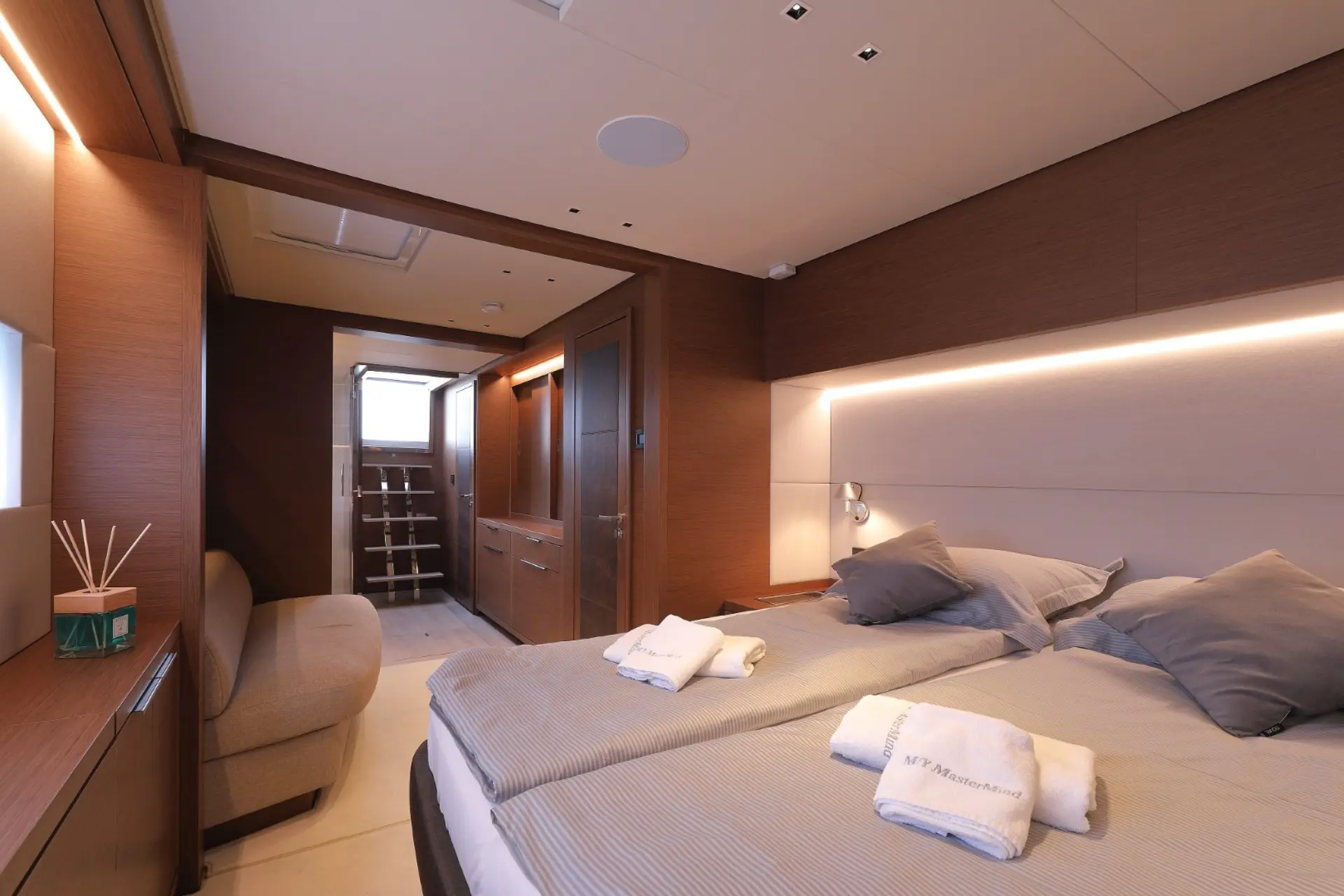 Mastermind cozy double cabin with bed, sofa, and small ladder to deck.