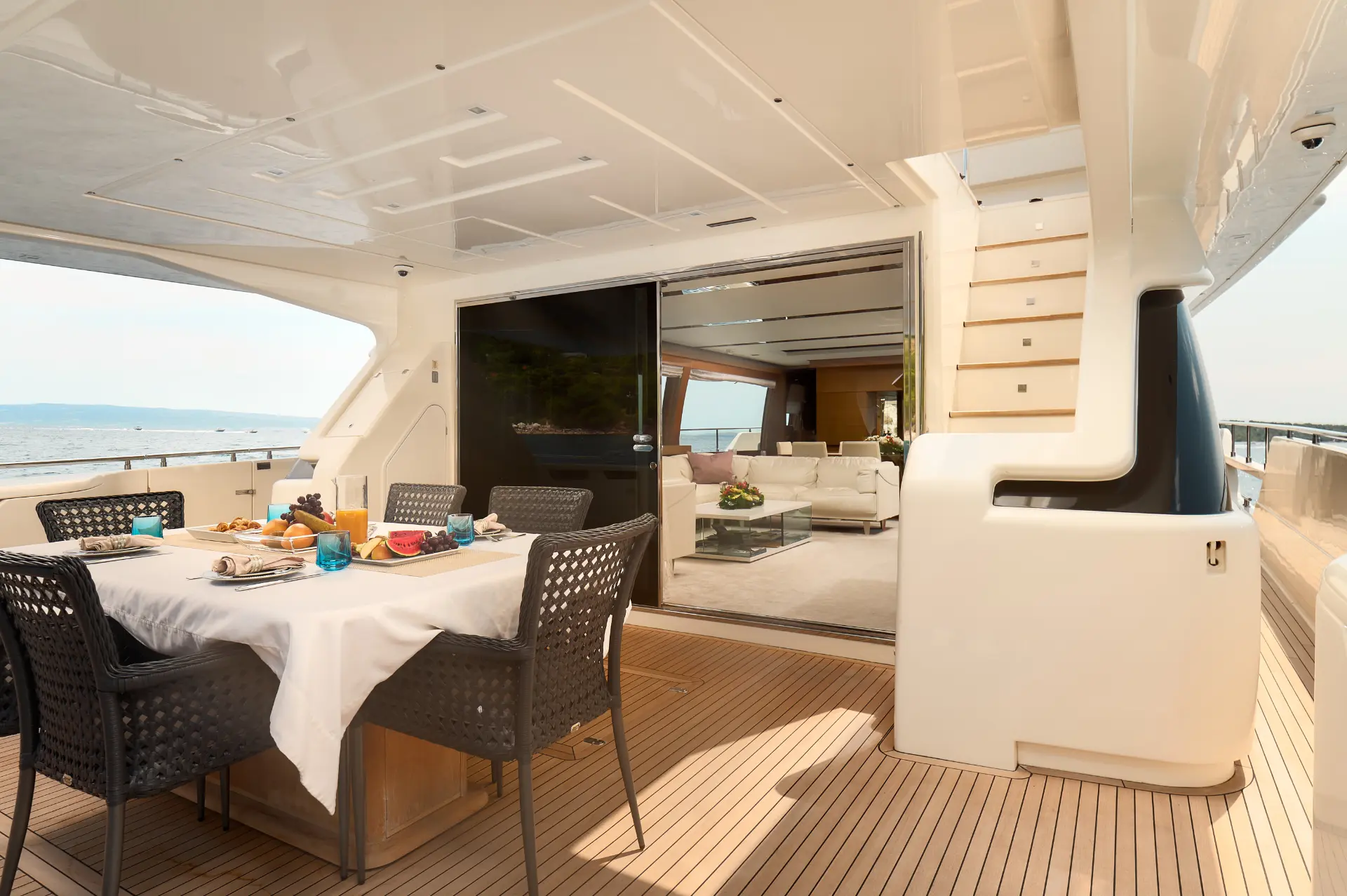 Iva – aft dining area with table, view directed toward the entrance into the elegant salon.