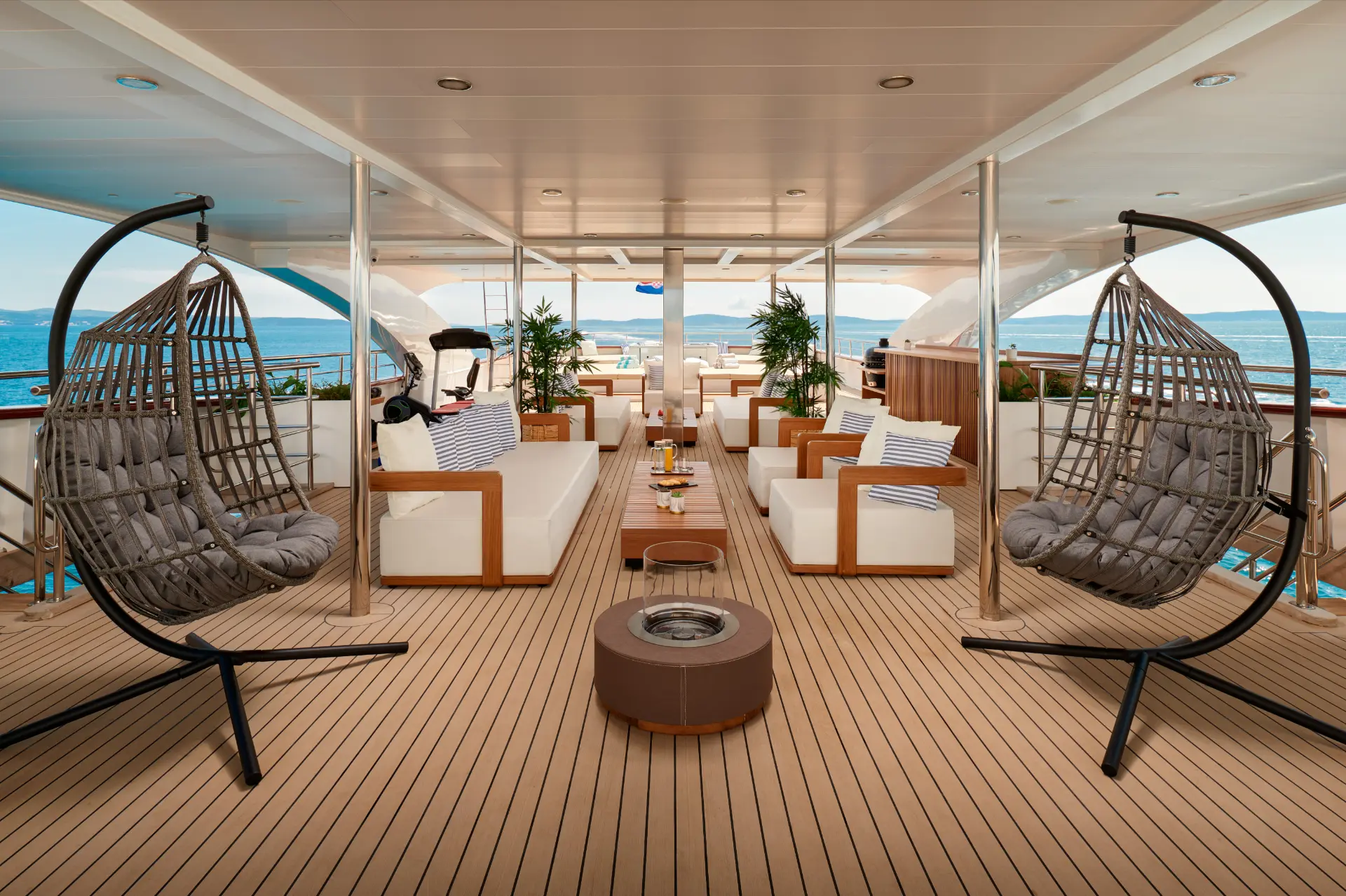 Sundeck on Ohana featuring swinging chairs, open fire, and cozy seating on beautiful teak deck