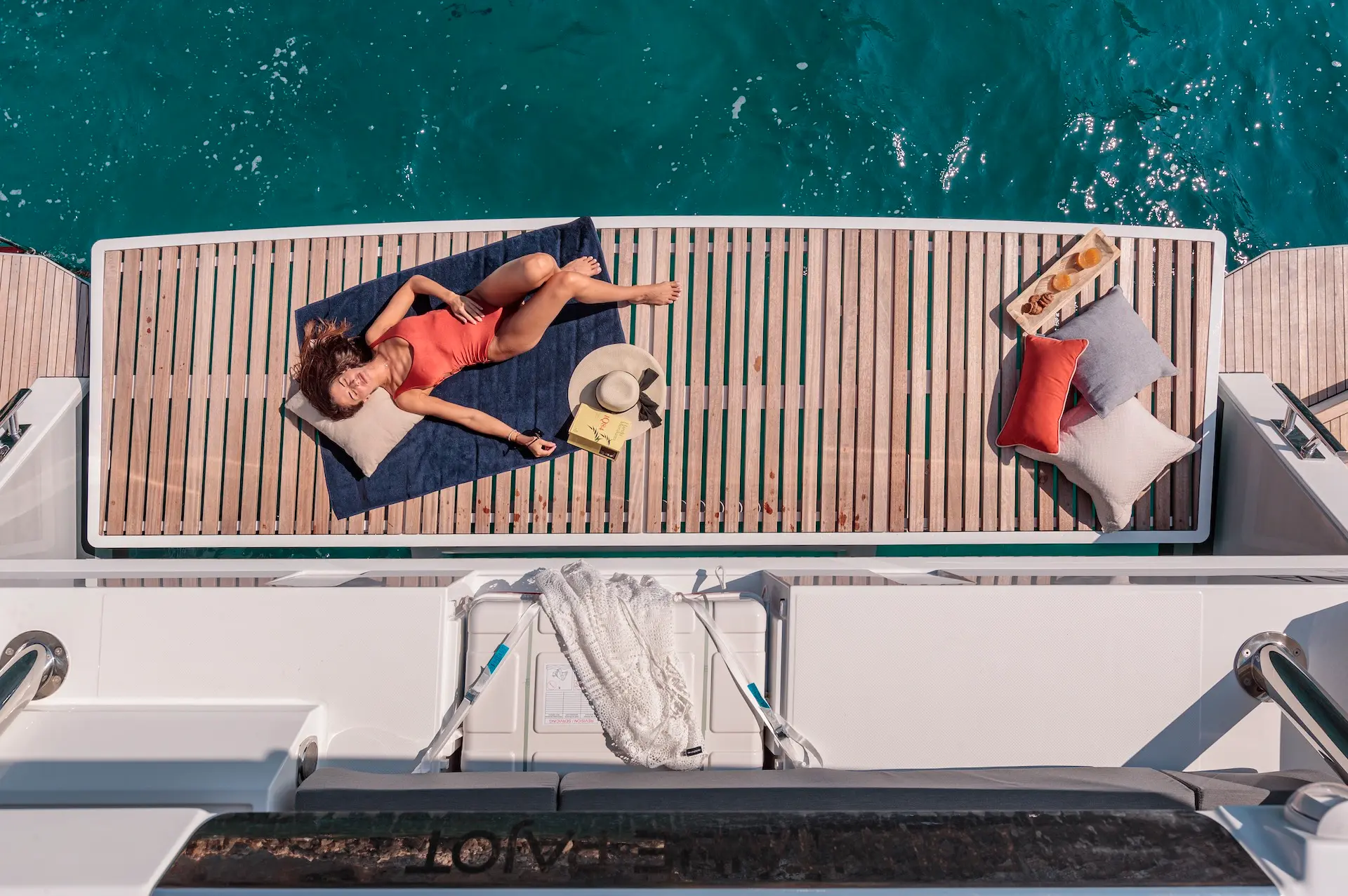 Solomar - top aerial close-up showing teak swim platform and sunbathing lady.