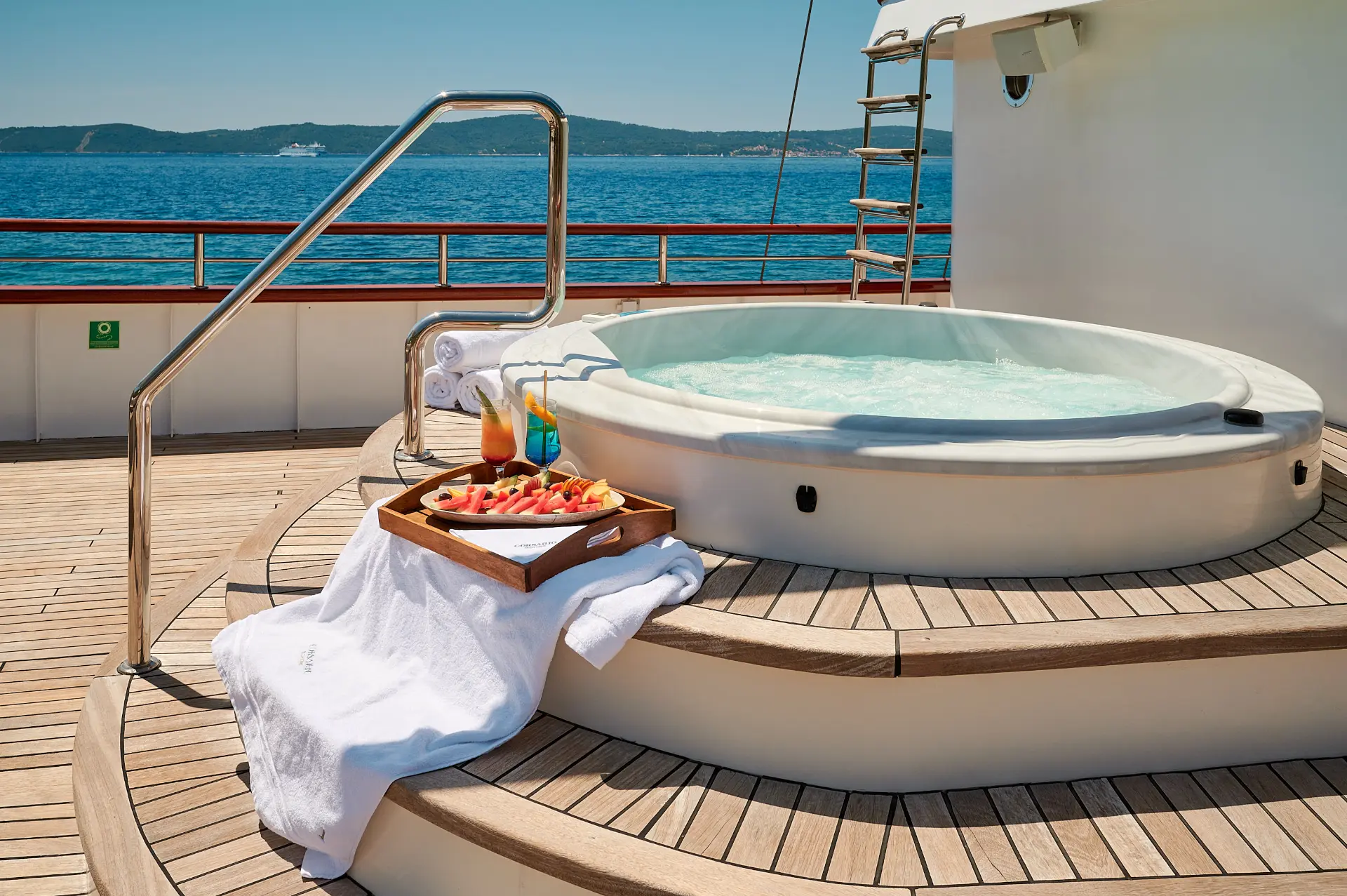 Close view of Corsario jacuzzi, cocktails and fresh fruits on steps, clear water, luxury vibe, sunny and relaxing atmosphere