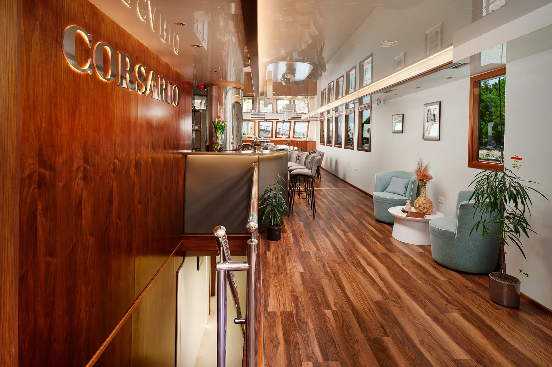 Salon interior showing bar up front, dining and lounge areas beyond, with wood flooring and accents.