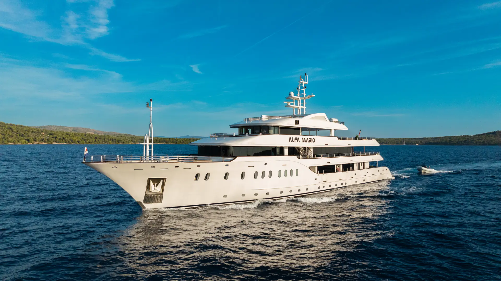 Luxury mini cruiser Alfa Mario - cruising front side view, showcasing modern design and multi-level decks in open water