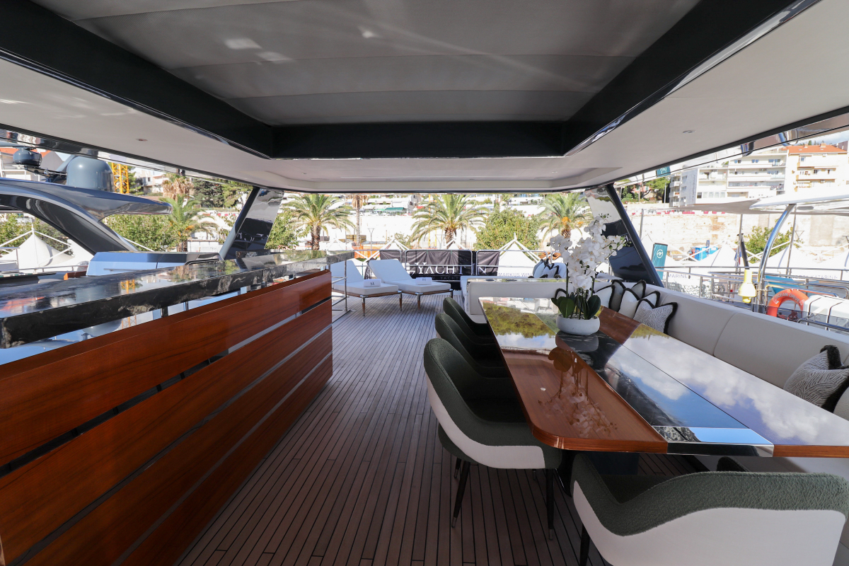 Luxury motor yacht Majera – flybridge layout featuring aft bar and spacious dining setup.