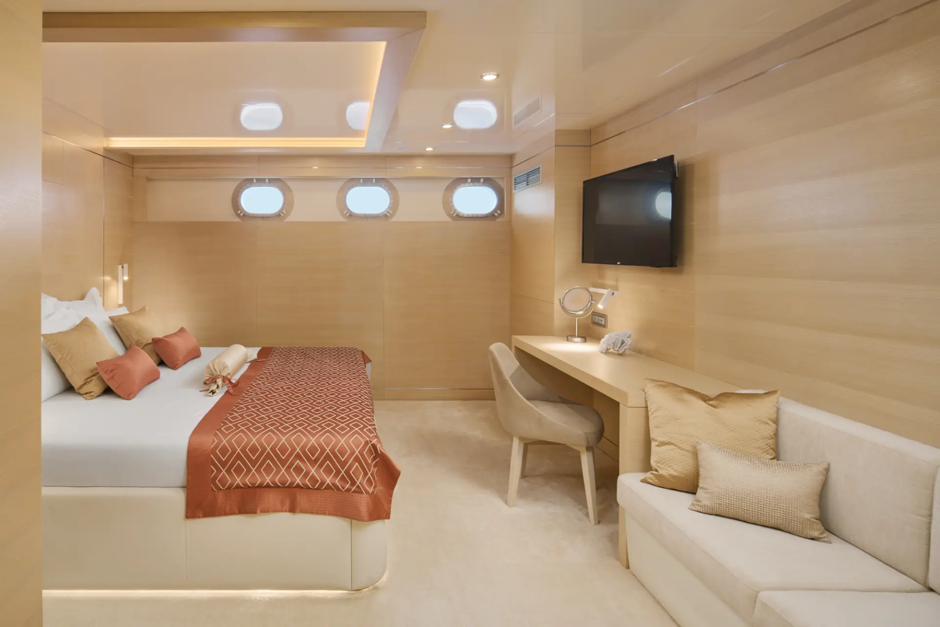 Elegant double cabin in white with warm brown and red decor, includes bed, desk, TV and comfy seating area.