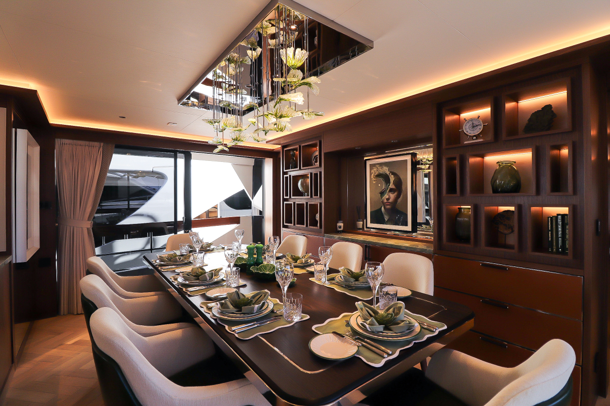 Majera – antique-style dining table viewed from side, tableware neatly arranged, art adorning the walls.