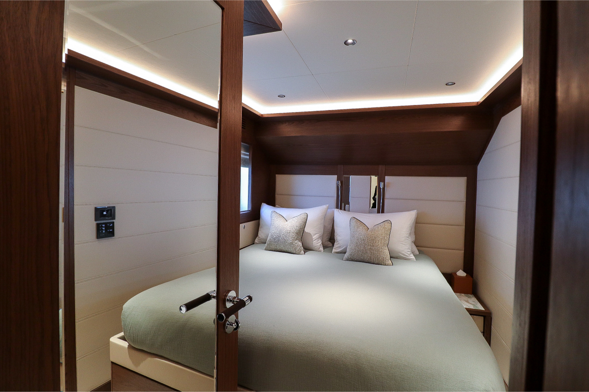 Cozy double bedroom with wooden interior, visible through an open door.