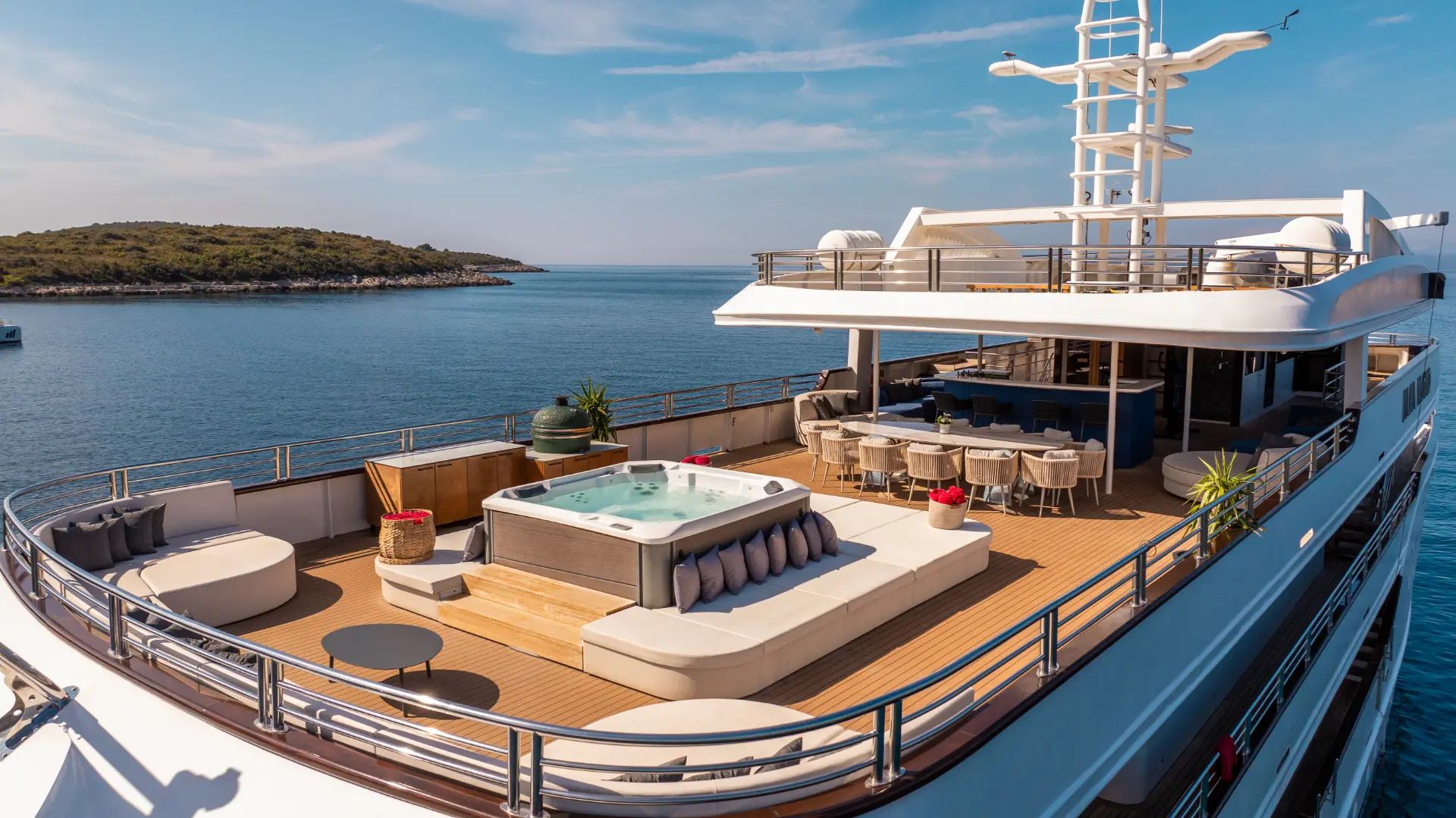Alfa Mario - close aft side view showing jacuzzi, lounge area, dining table, and bar on sundeck