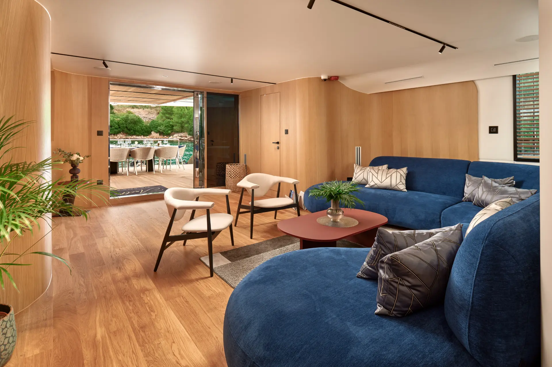 Anetta salon showcasing a blue L-shaped sofa and small table, view directed towards entrance.