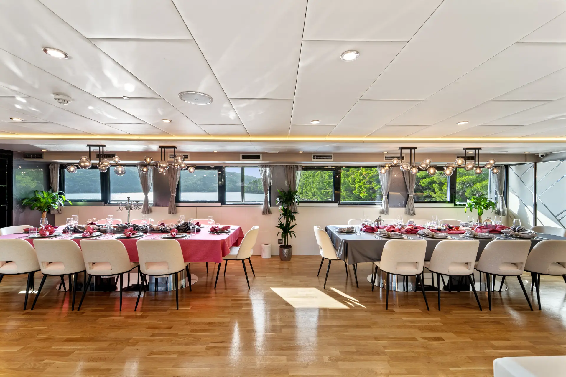 Freedom – interior salon featuring two dining tables set below windows