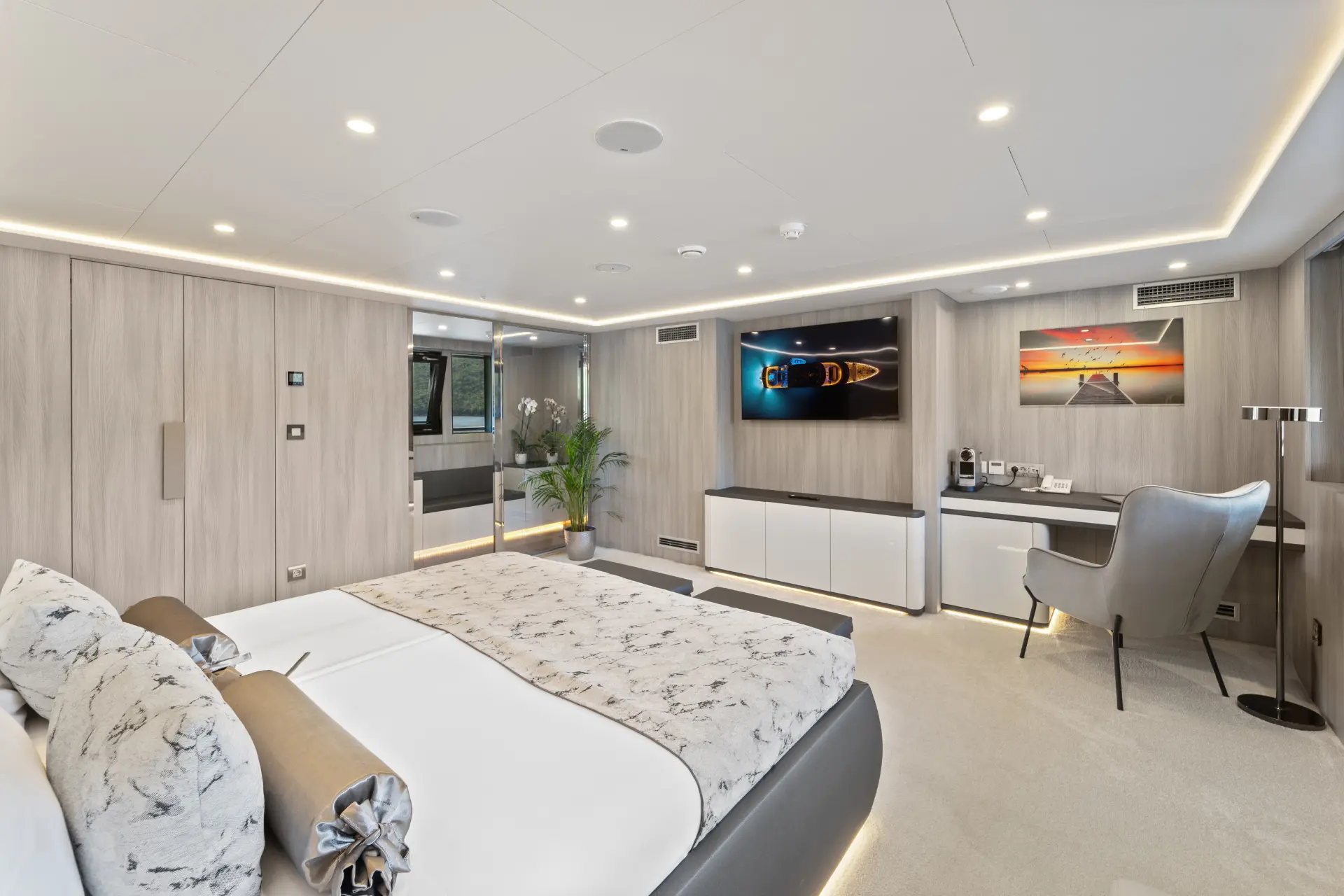 Freedom - Bright and modern cabin with double bed, view from bed towards TV, wall art, desk, and small plants