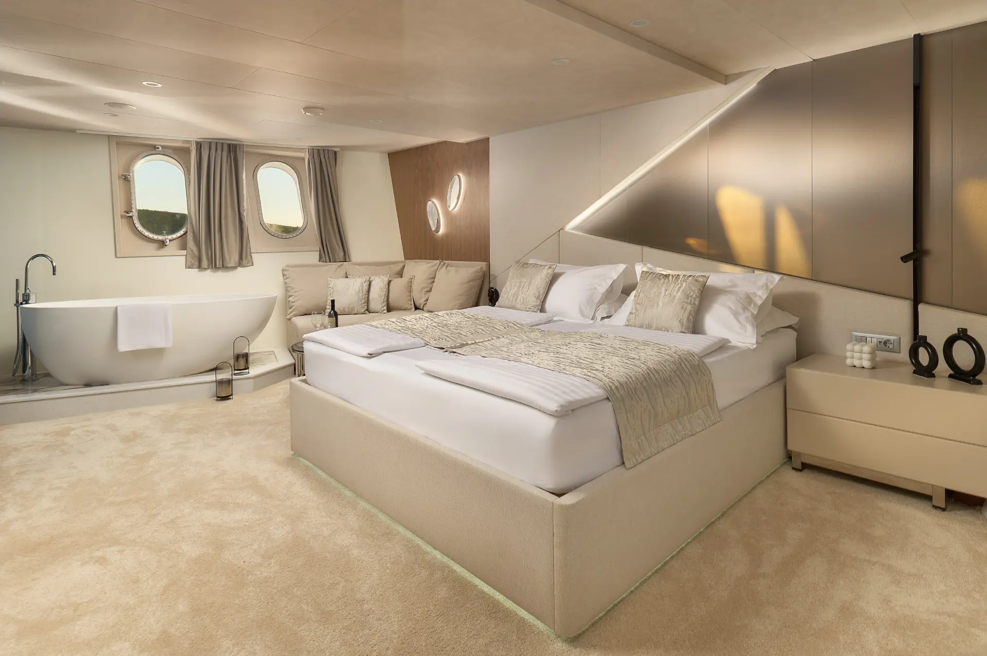 Cristal master bedroom with plush bed, white comfortable seating, and a freestanding bathtub