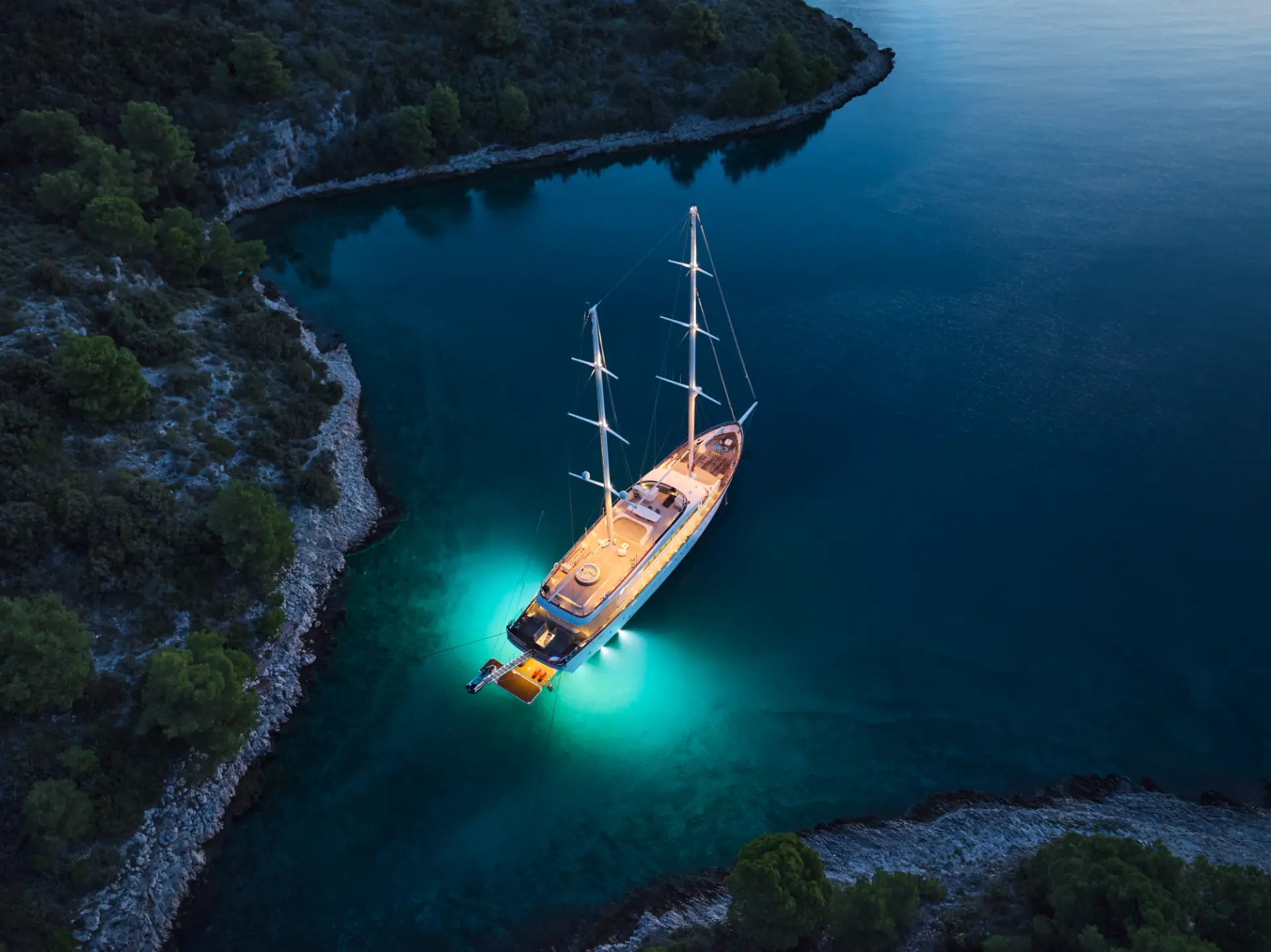 Love Story anchored in the bay, aerial aft view at night,.