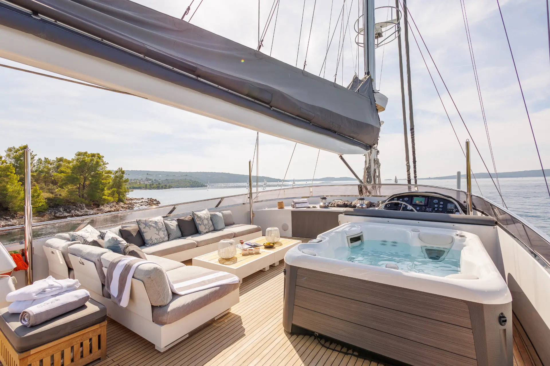 San Limi – spacious sun deck featuring jacuzzi, lounge area, table, and helm station with sea views