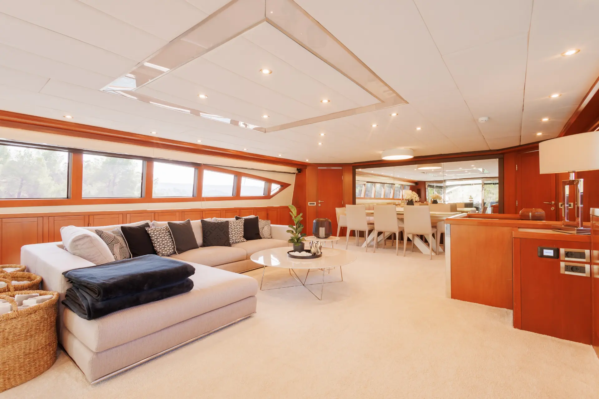 San Limi – elegant salon featuring wood accents, L-sofa with round table, and large dining table seating eight