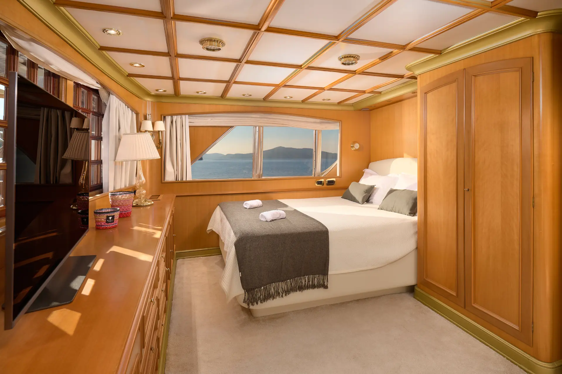 To je To – elegant upper deck cabin, bed side view, large window behind, left TV, wooden interior accents