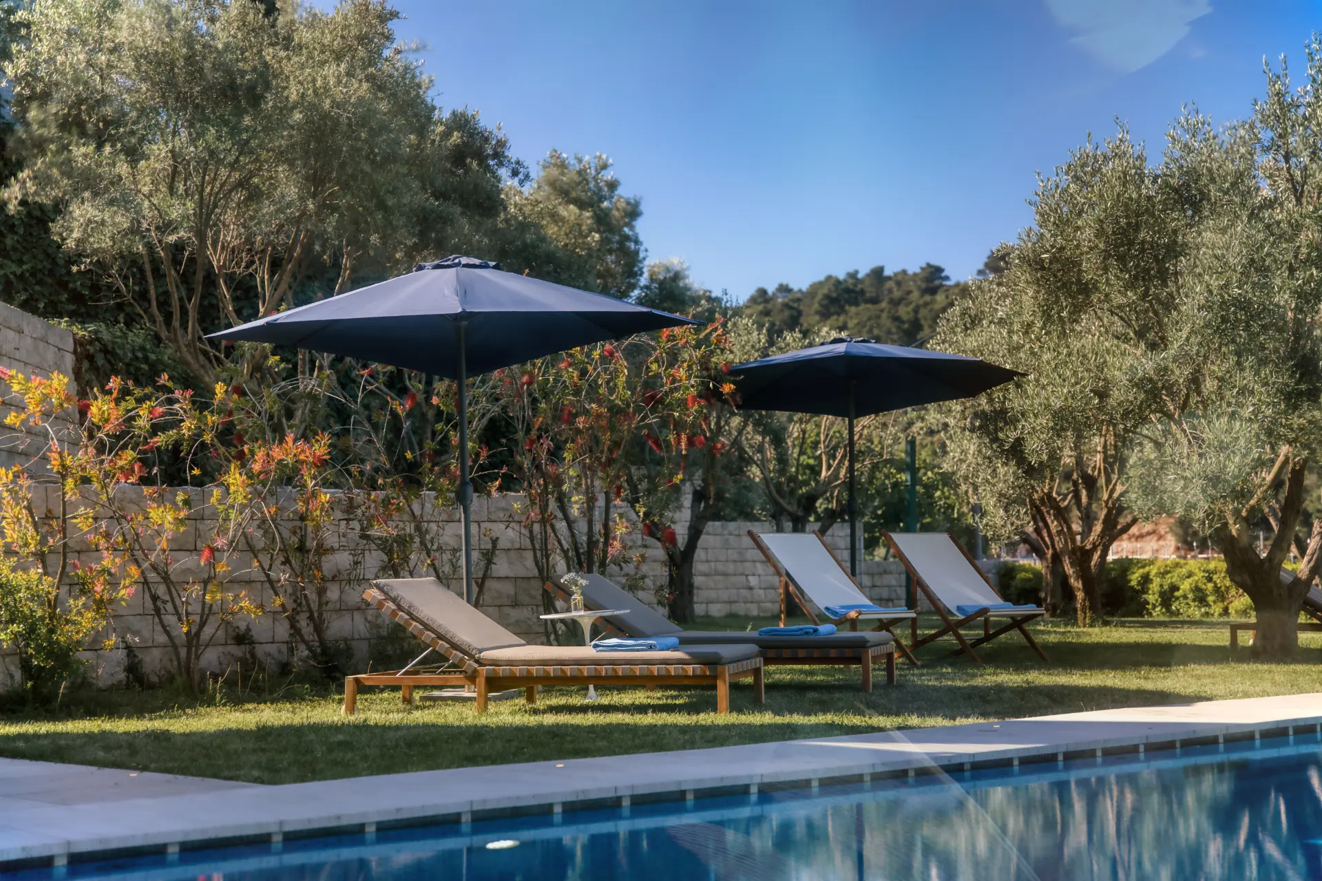 Luxury Island Estate near Dubrovnik – poolside with 4 loungers and 2 umbrellas next to the sparkling outdoor pool