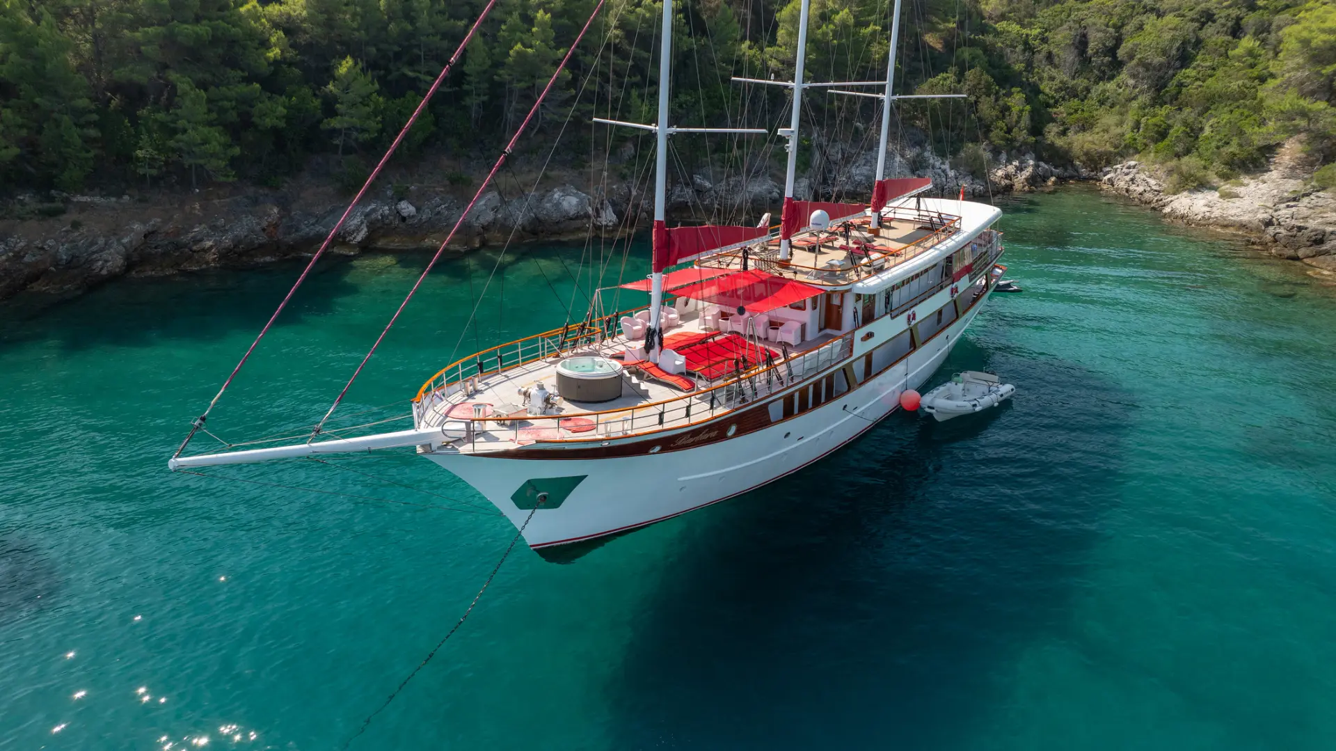 Barbara - elegant yacht with visible foredeck, anchored in turquoise bay.