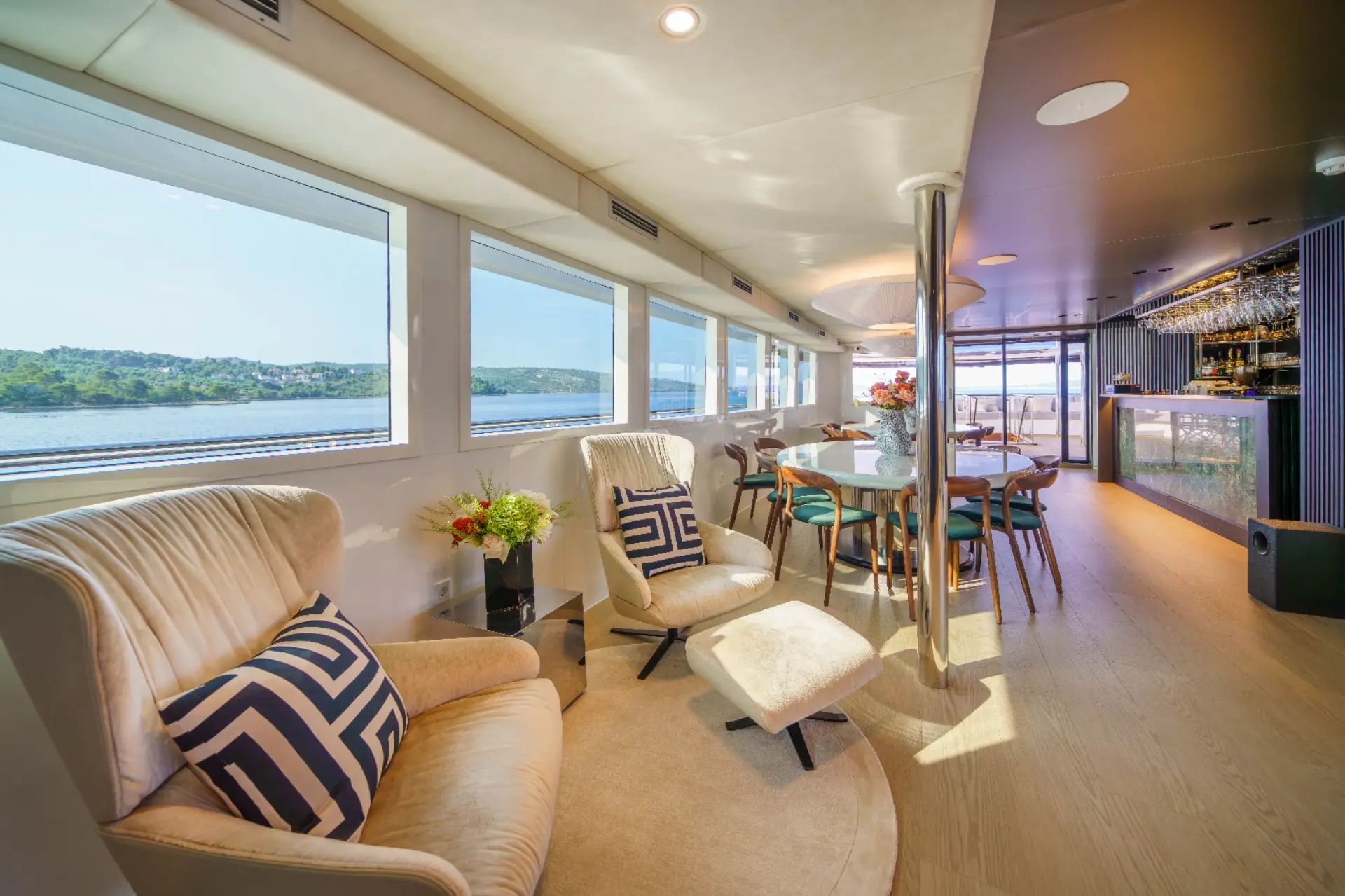Agape Rose - Bright salon: View toward the entrance; sitting area foreground, dining background, large windows.