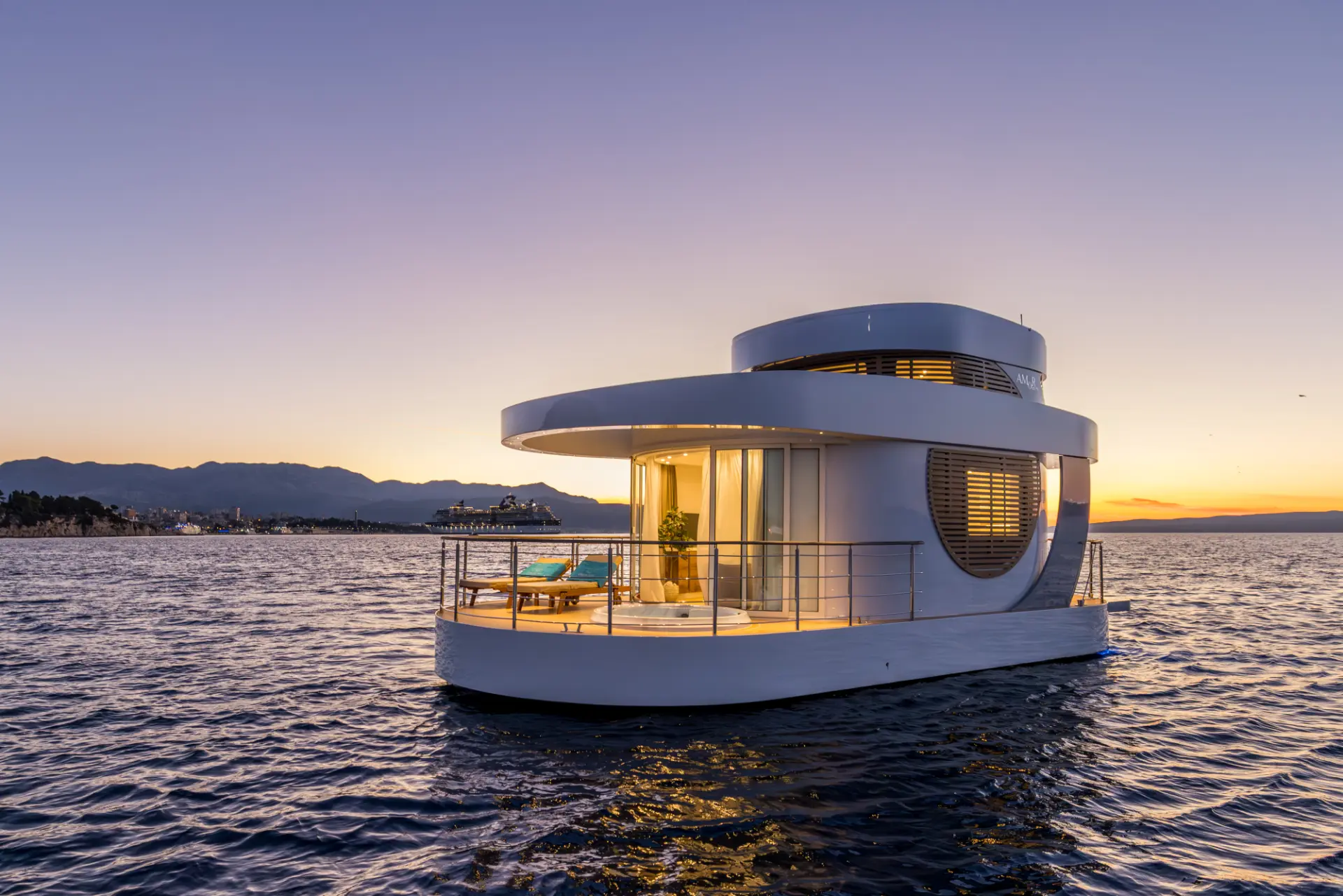 Floating house Amor illuminated on the sea at sunset with Split in the background, Croatia
