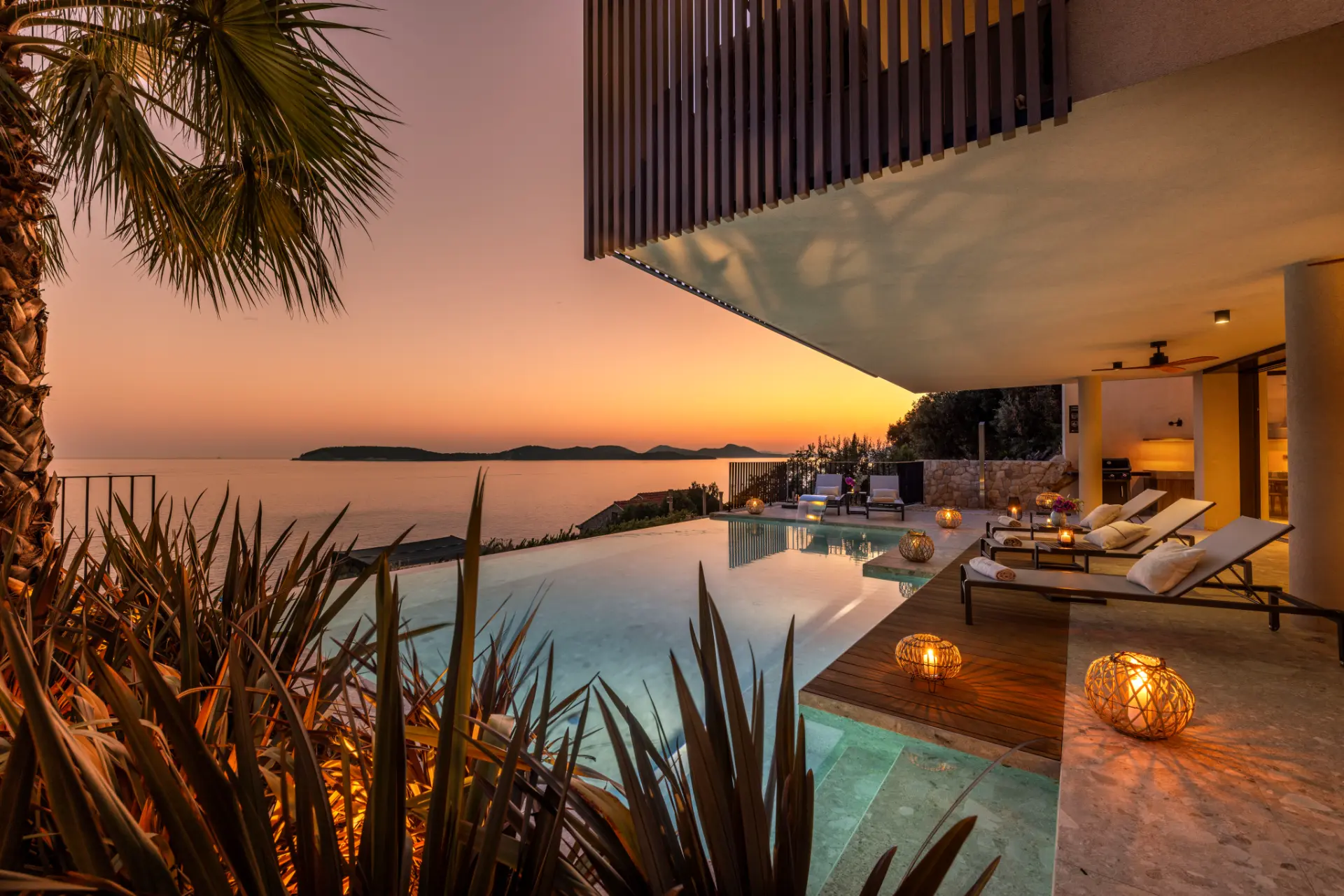 Luxury villa Dubrovnik - Villa Lumea, evening front view of illuminated pool, luxury loungers and ambient lighting overlooking the sea