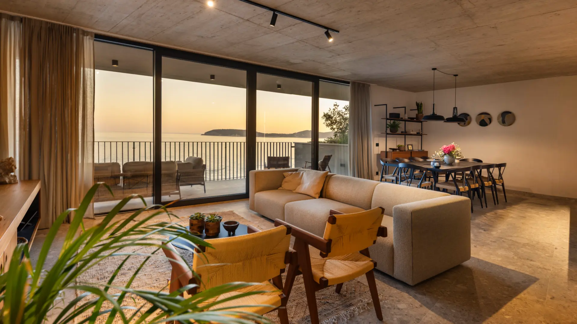 Villa Lumea, spacious living and dining area with floor-to-ceiling glass walls, terrace seating and panoramic sea view